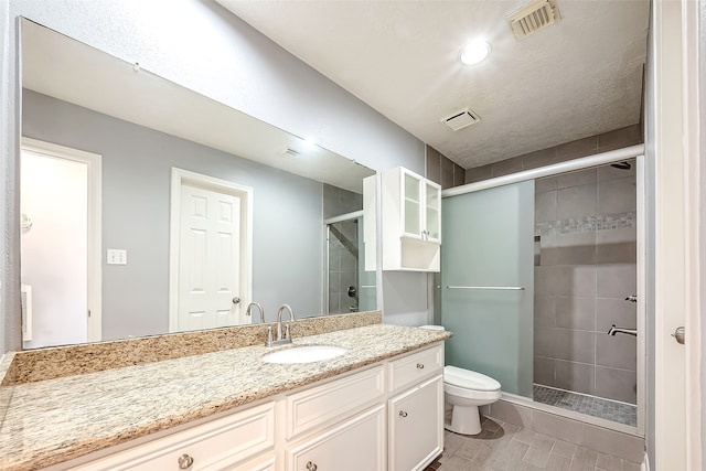 bathroom featuring an enclosed shower, vanity, and toilet