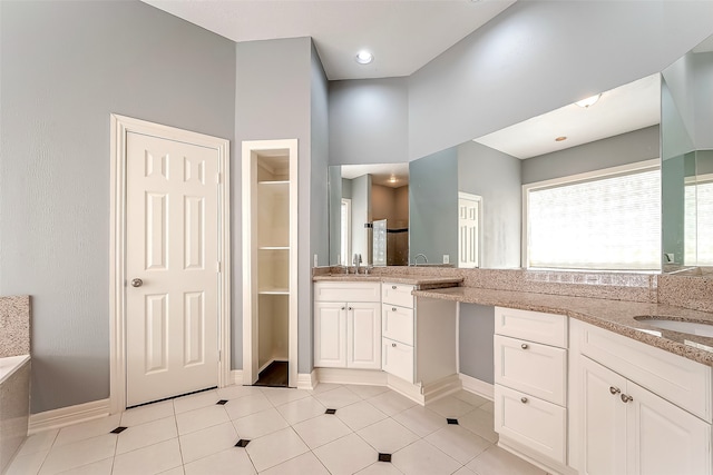 bathroom featuring vanity, a tub, and tile patterned flooring