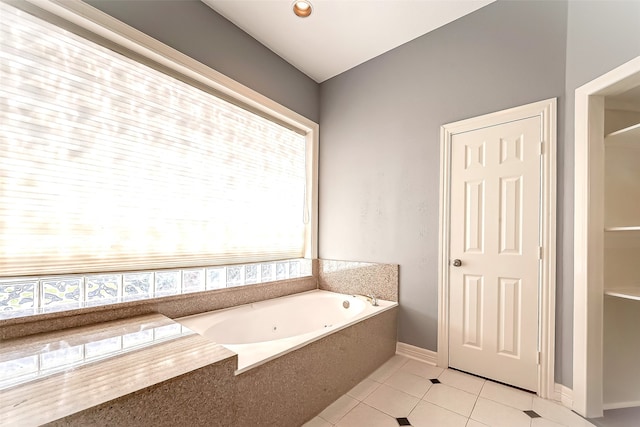 bathroom with a tub to relax in and tile patterned floors