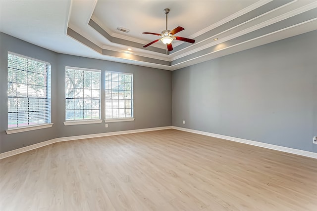 unfurnished room featuring ornamental molding, ceiling fan, a tray ceiling, and light hardwood / wood-style floors