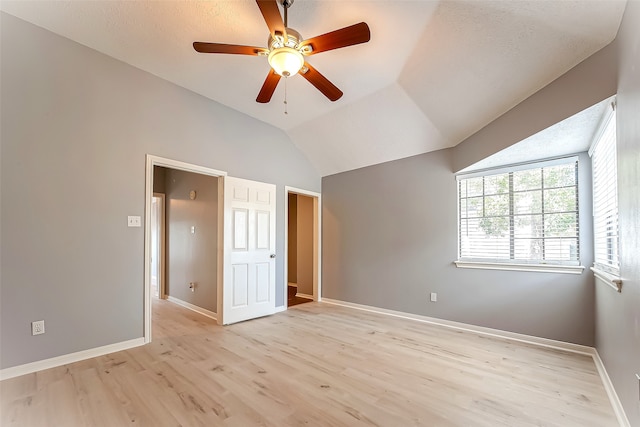 unfurnished bedroom with a textured ceiling, light hardwood / wood-style flooring, ceiling fan, and vaulted ceiling