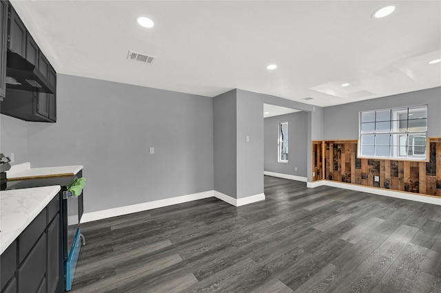 unfurnished living room featuring dark hardwood / wood-style floors and wooden walls