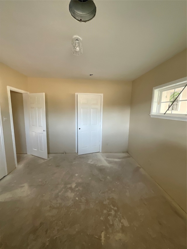 unfurnished bedroom featuring concrete floors