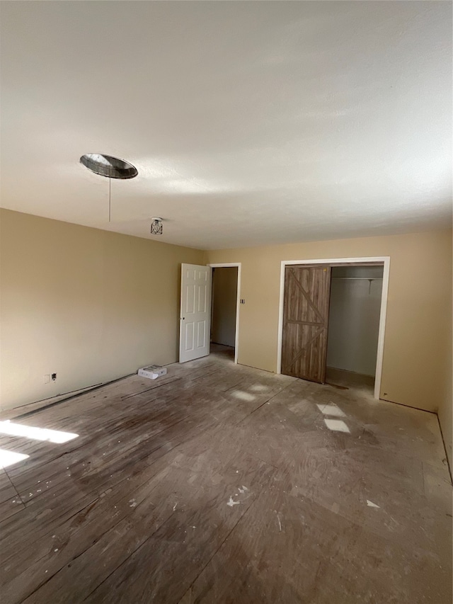 unfurnished bedroom with a closet and a barn door