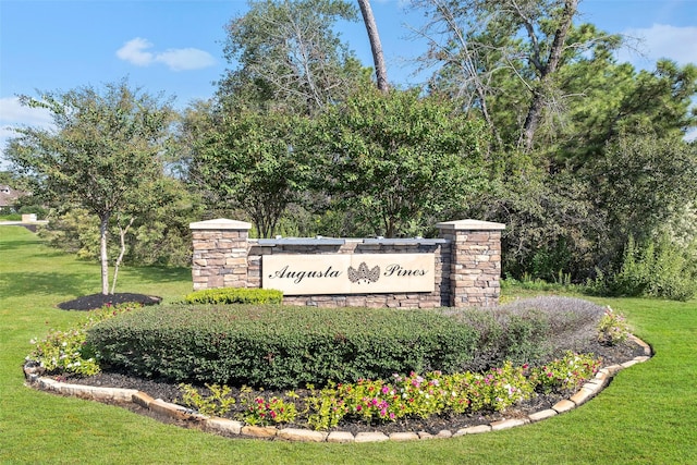 community / neighborhood sign with a yard