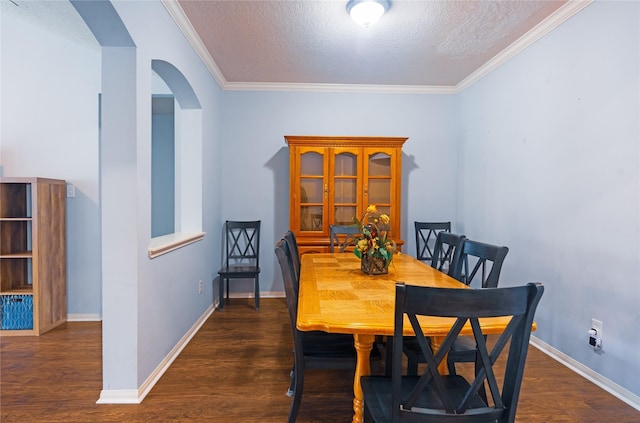 dining space featuring dark hardwood / wood-style floors, ornamental molding, and a textured ceiling