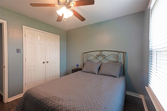 bedroom featuring multiple windows, a closet, ceiling fan, and dark hardwood / wood-style floors