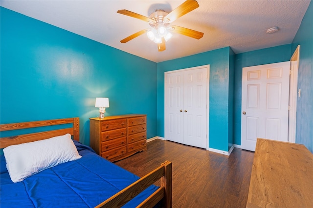 bedroom with a textured ceiling, ceiling fan, a closet, and dark hardwood / wood-style floors