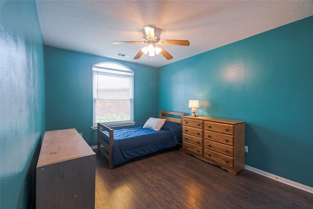 bedroom featuring a textured ceiling, ceiling fan, and dark wood-type flooring