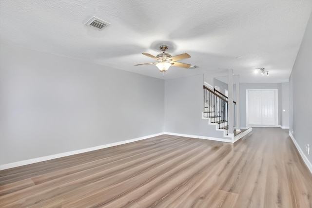 spare room featuring ceiling fan, a textured ceiling, and light wood-type flooring