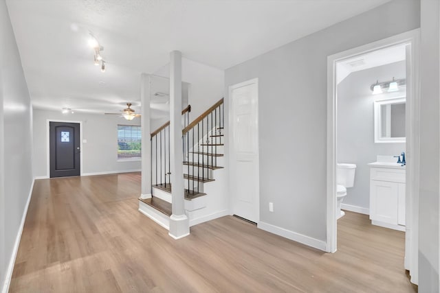 stairs featuring hardwood / wood-style flooring and ceiling fan