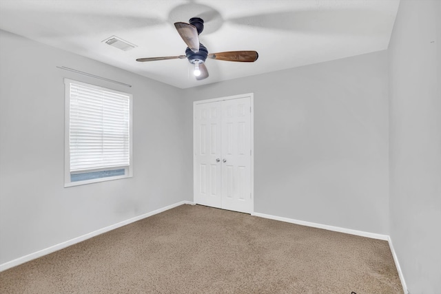 spare room with ceiling fan and carpet