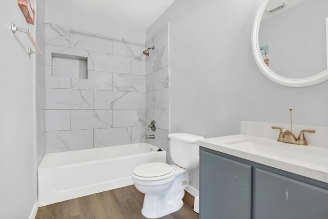 full bathroom featuring hardwood / wood-style flooring, toilet, vanity, and tiled shower / bath