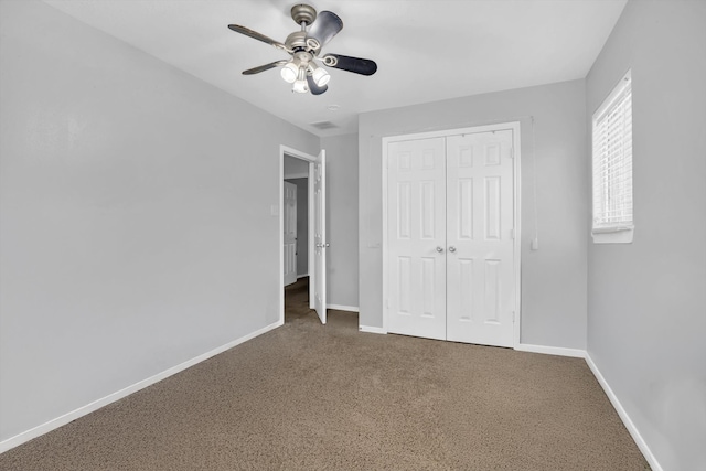 unfurnished bedroom with ceiling fan, a closet, and carpet flooring