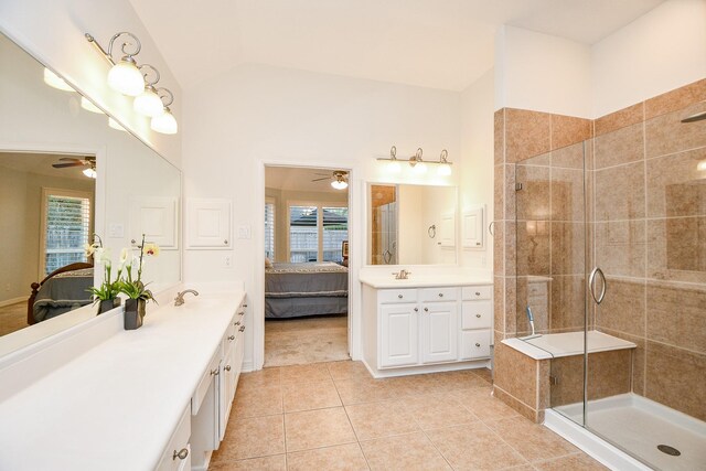 bathroom with tile patterned floors, ceiling fan, a healthy amount of sunlight, and lofted ceiling