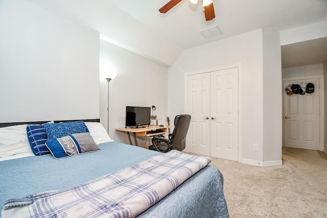 carpeted bedroom with ceiling fan, a closet, and vaulted ceiling