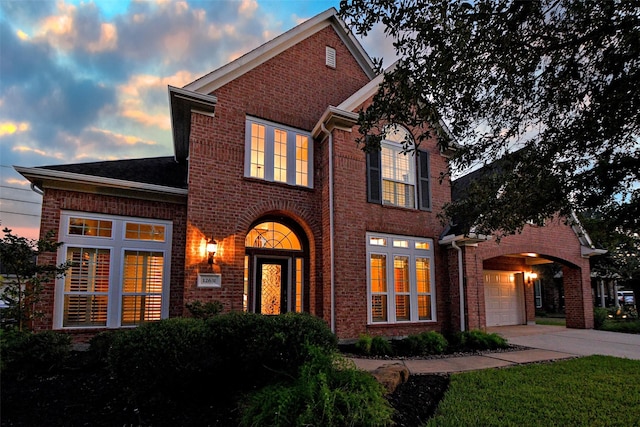 traditional home with concrete driveway and brick siding