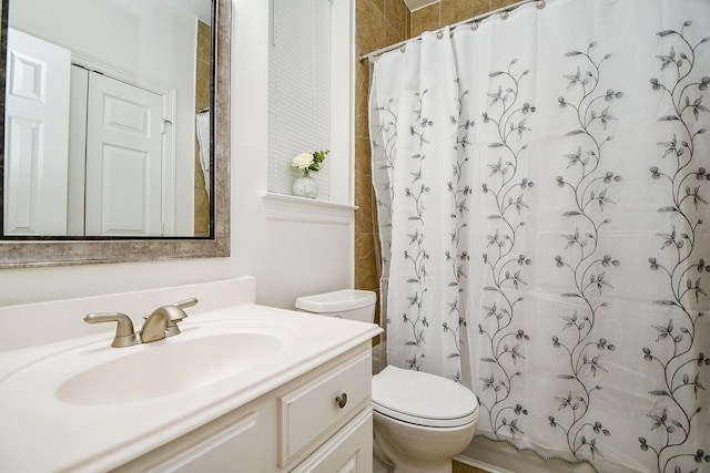 bathroom with toilet, curtained shower, and vanity