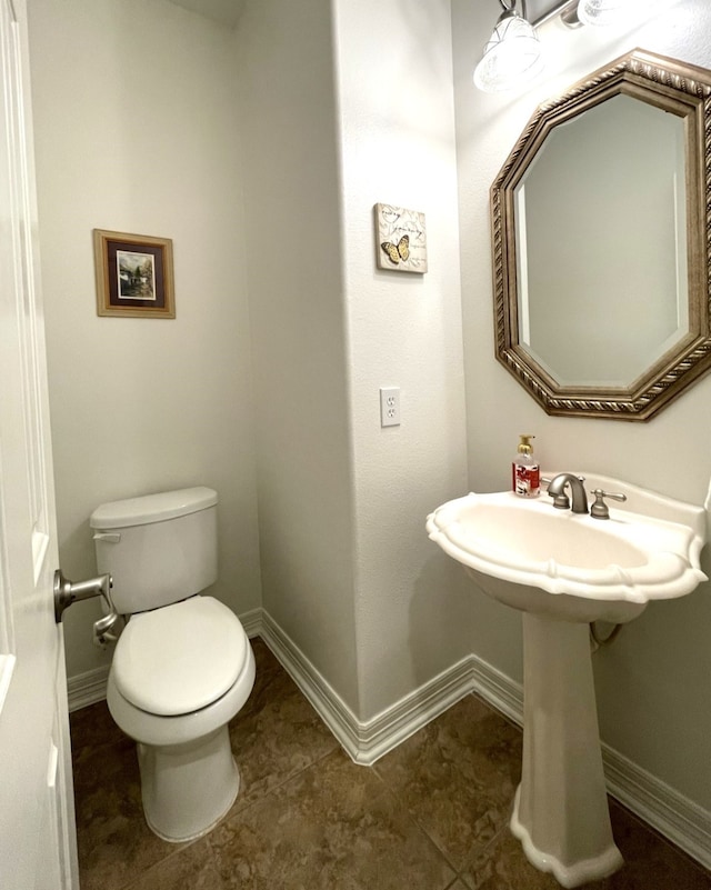 bathroom featuring tile patterned floors, baseboards, and toilet