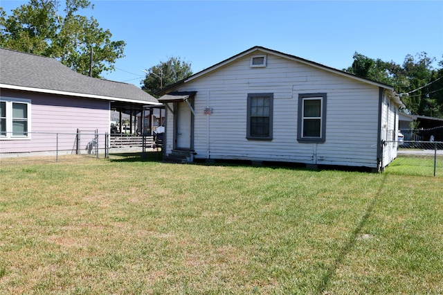 rear view of property featuring a yard