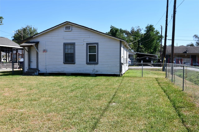 rear view of property featuring a yard