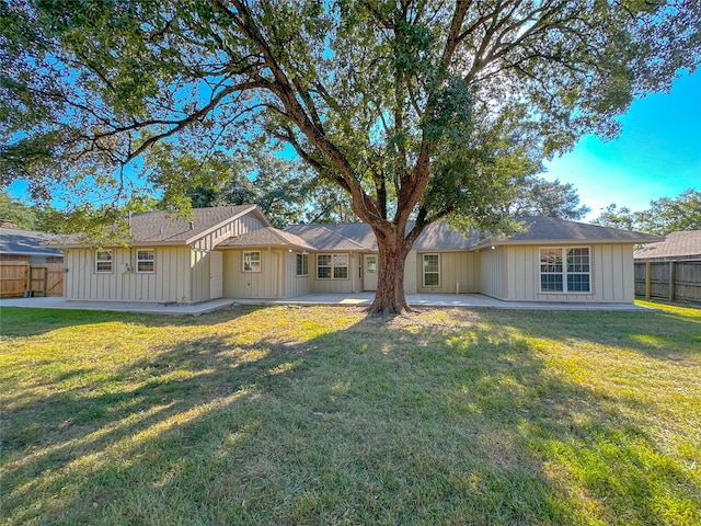 back of property featuring a lawn and a patio