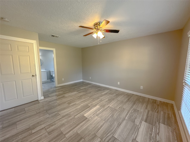 spare room featuring a textured ceiling, ceiling fan, and light hardwood / wood-style flooring