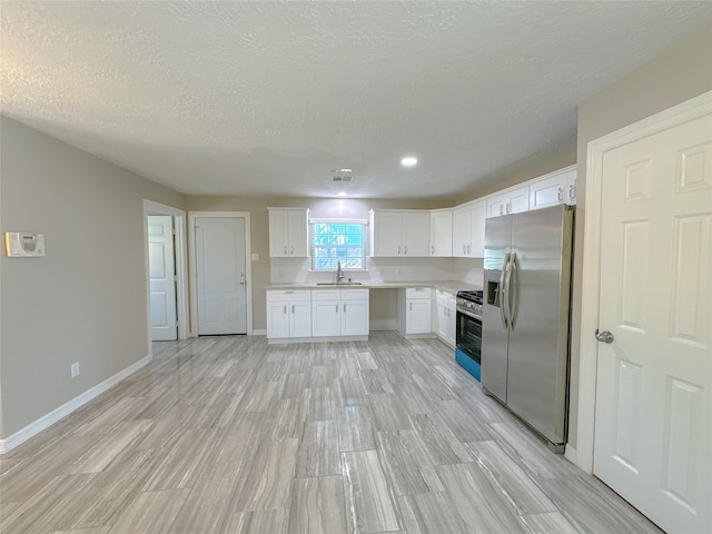 kitchen with stainless steel appliances, light hardwood / wood-style floors, white cabinets, and sink