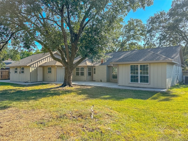 rear view of property with a patio and a lawn