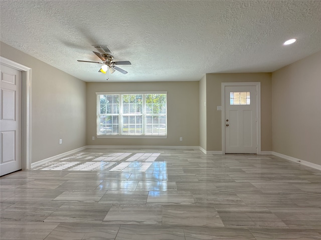 entryway featuring ceiling fan, plenty of natural light, and a textured ceiling