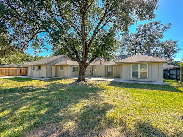 rear view of property with a lawn and a patio area