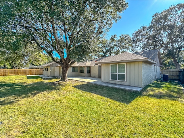 back of house with a shed, a lawn, a patio, and central AC