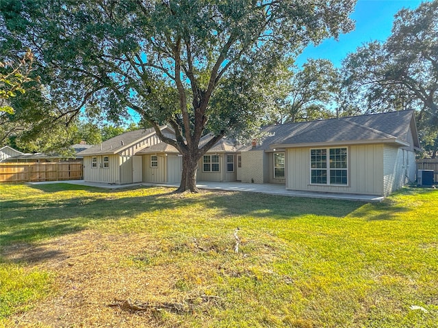 back of property with cooling unit, a yard, and a patio area