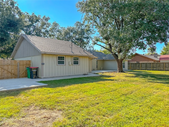 rear view of property with a yard and a patio area