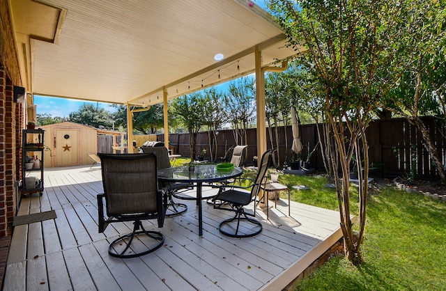 wooden deck featuring a storage shed and a lawn