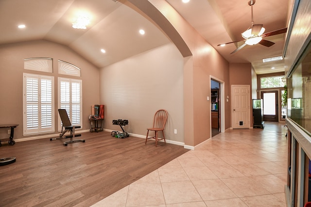 exercise room with lofted ceiling, ceiling fan, and light hardwood / wood-style flooring