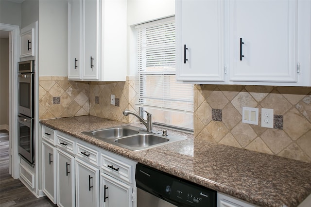 kitchen with dark hardwood / wood-style floors, sink, backsplash, appliances with stainless steel finishes, and white cabinetry