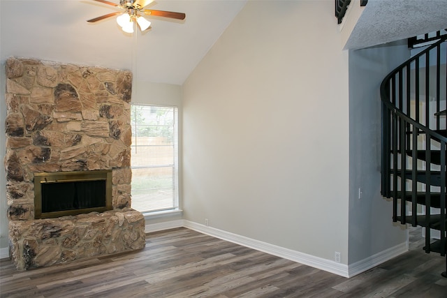 unfurnished living room with ceiling fan, dark hardwood / wood-style floors, high vaulted ceiling, and a stone fireplace