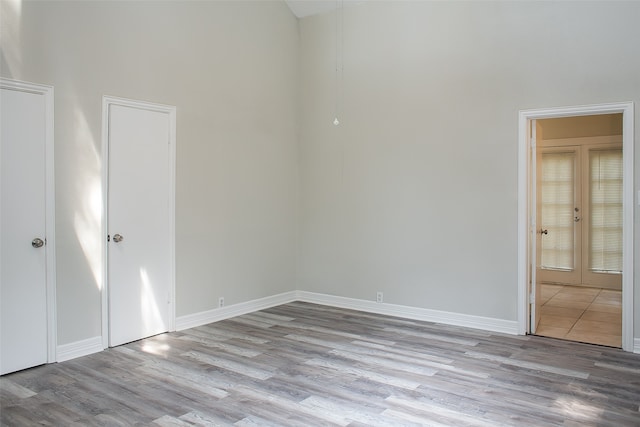 spare room with french doors and light hardwood / wood-style flooring