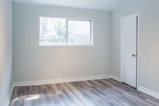 unfurnished room featuring light hardwood / wood-style flooring and lofted ceiling