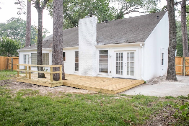 back of property featuring a yard, a wooden deck, and french doors