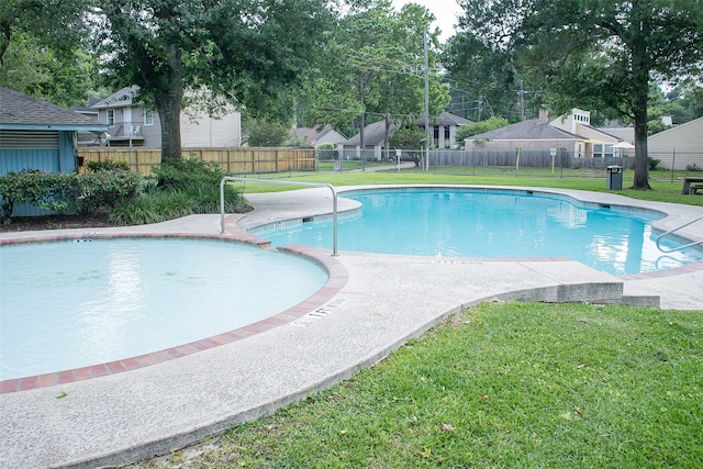 view of pool with a lawn and a patio