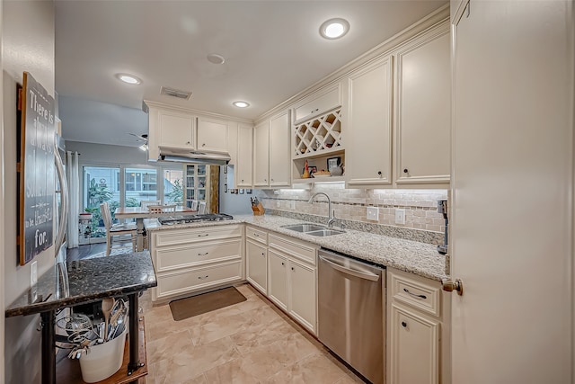 kitchen featuring kitchen peninsula, sink, appliances with stainless steel finishes, light stone counters, and white cabinetry