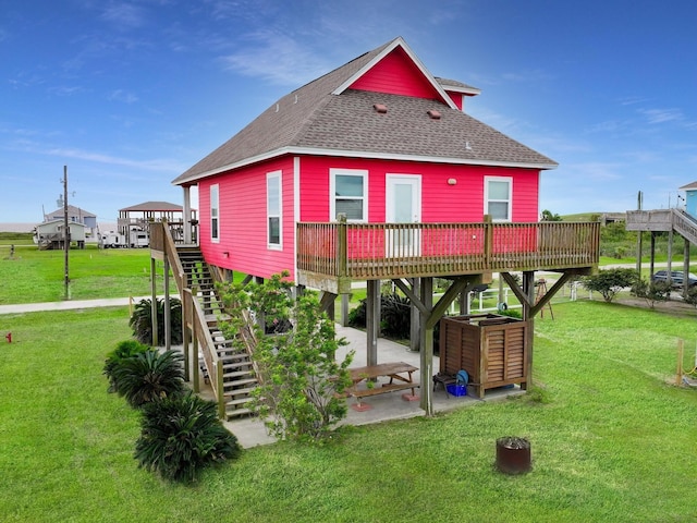 back of property with a wooden deck and a lawn