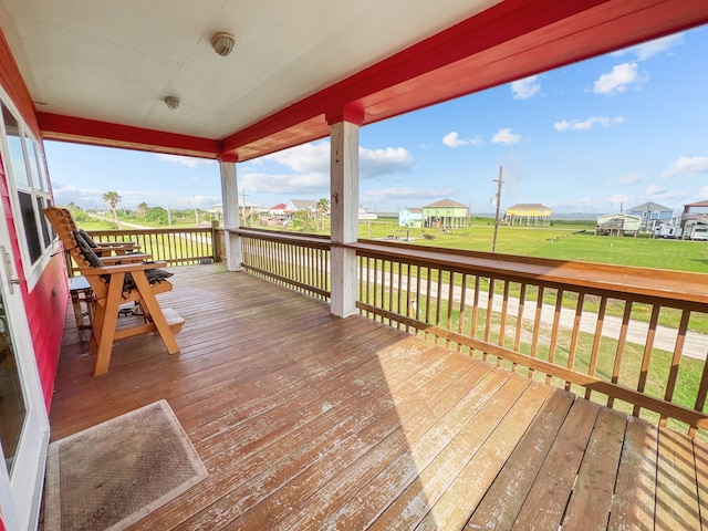 wooden deck featuring a lawn