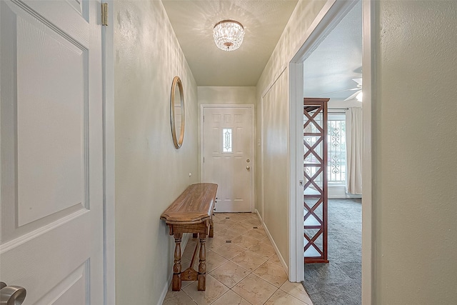 interior space featuring light tile patterned floors and ceiling fan with notable chandelier