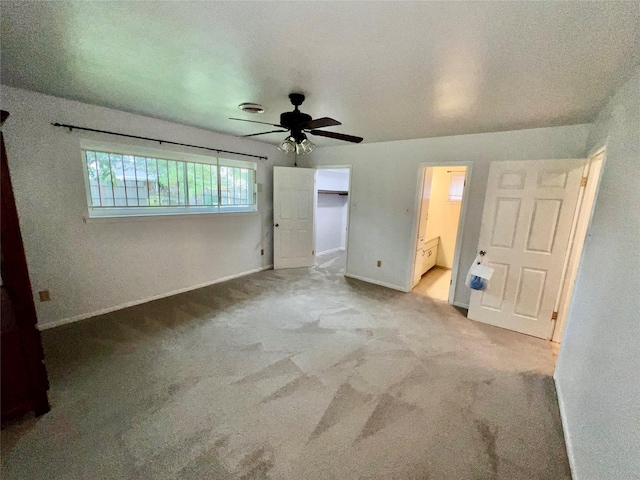 unfurnished bedroom featuring ensuite bathroom, ceiling fan, and light carpet