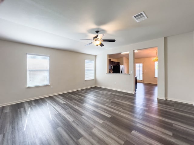 unfurnished living room with dark wood-type flooring and plenty of natural light