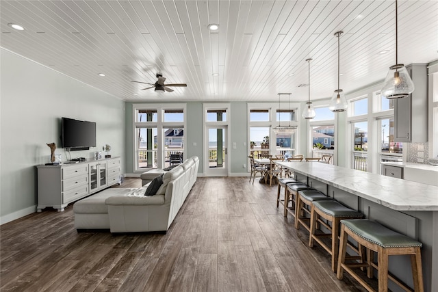 living room with dark hardwood / wood-style flooring, wood ceiling, and plenty of natural light