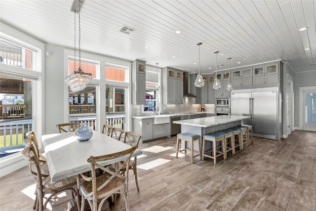 dining space featuring ornamental molding, hardwood / wood-style floors, an inviting chandelier, and wooden ceiling